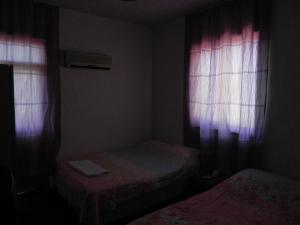 a small room with two beds and two windows at Sunrise Hotel in Antalya