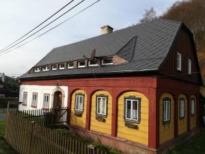 a red and yellow house with a black roof at Apartmán 141 in Chřibská