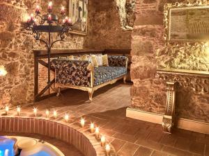 ein Wohnzimmer mit Sofa und Kerzen auf dem Boden in der Unterkunft Solar Antigo Luxury Spa Coimbra in Coimbra