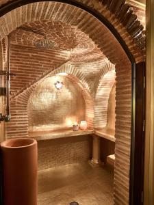a brick archway in a room with a trash can at Solar Antigo Luxury Spa Coimbra in Coimbra +9 photos