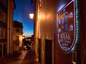 ein Schild für ein Restaurant an der Seite eines Gebäudes in der Unterkunft Solar Antigo Luxury Spa Coimbra in Coimbra