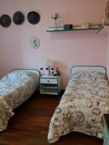 1 dormitorio con 2 camas y mesa con colcha en B&B da Jordan, en Gorgonzola