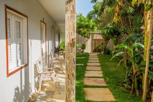 a garden with a walkway next to a house at Pousada Barros in Jericoacoara