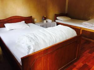 two beds in a room with white sheets at Shrestha Hotel & Restaurant in Bandipur +26 photos