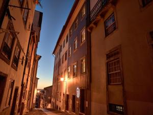 eine Gasse in einer alten Stadt nachts in der Unterkunft Solar Antigo Luxury Spa Coimbra in Coimbra