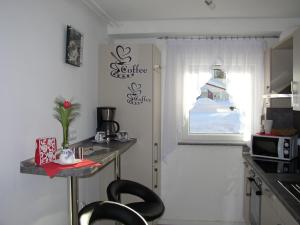 eine kleine Küche mit Tisch und Fenster in der Unterkunft Herzlich & Harzlich Willkommen in Braunlage + 9 Fotos