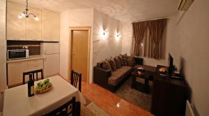 a kitchen and a living room with a couch and a table at Apartman Vanja in Bar