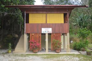 a small building with flowers in front of it at Country house Pulai Holiday Village in Gua Musang