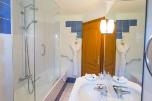a bathroom with a sink and a shower and a tub at Hôtel Restaurant Du Port in Yvoire