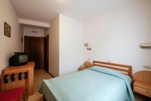 ファッラ・ダルパーゴにあるAlbergo De Marchのベッドルーム(青いベッド1台、テレビ付)