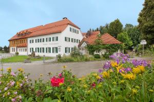 um grande edifício branco com flores em frente em Landgasthof - Hotel Reindlschmiede em Bad Heilbrunn