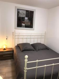 a bedroom with a bed and a picture on the wall at L'Atelier Zen in Sarreguemines +33 photos