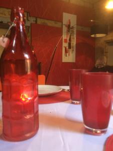 サルラ・ラ・カネダにあるAppartement de charme centre historique Sarlatの- ボトル入り飲料水1本、テーブル上のグラス2杯