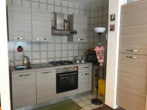 uma pequena cozinha com um fogão e um lavatório em Appartamento Saint Gréé em Viola