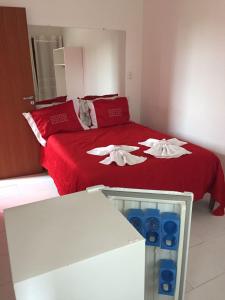 a bedroom with a red bed with two white towels at Chalés Colina de Casa Branca in Brumadinho
