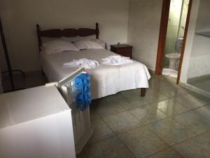 a bedroom with a bed with towels on it at Chalés Colina de Casa Branca in Brumadinho