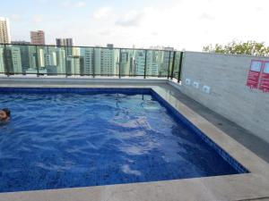 una persona en una piscina en la parte superior de un edificio en Flats Deco Design Beira Mar Prime en Recife