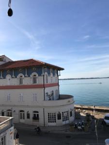 - un grand bâtiment à côté d'une étendue d'eau dans l'établissement Allure Apartments, à Piran