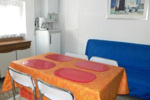 a kitchen with a table with red plates on it at Appartamento San Ambrogio in Cannobio