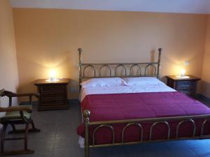 カンノビオにあるAppartamento Due Vialiのベッドルーム1室(ベッド1台付)、2泊分のスタンド(ランプ付)