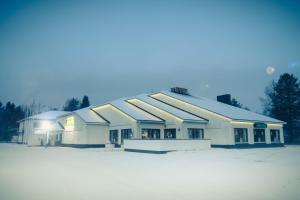 a large white building with snow on the ground at Hotel Kittilä in Kittilä