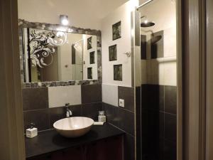 y baño con lavabo y espejo. en Le Faré Tchanqué Chambre d’hôtes Référence en Cavaillon