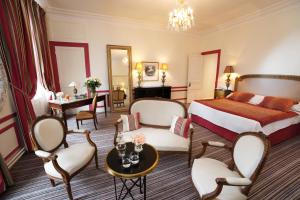 une chambre d'hôtel avec un lit, une table et des chaises dans l'établissement Pavillon Henri IV, à Saint-Germain-en-Laye