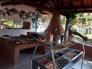 una cocina con una mesa con comida y botellas de vino en Chalés Colina de Casa Branca, en Brumadinho