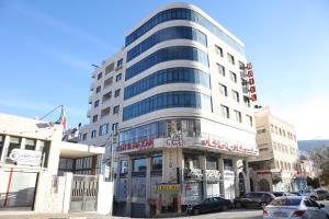 ein hohes Gebäude auf einer Stadtstraße mit Autos vor dem Haus in der Unterkunft Royal Suites in Nablus