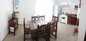 cocina con mesa, sillas y nevera en Las Rosas en Costa del Este