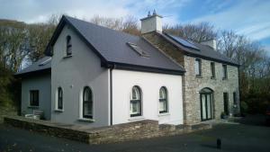 een witte kerk met een zwart dak bij SunnySide-Cottage in Ennistymon