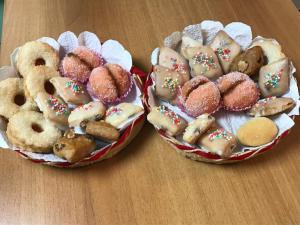 dos cestas de diferentes tipos de rosquillas sobre una mesa en Casa Vacanza Porto Frailis già Porto Frailis B&B en Àrbatax