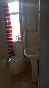 a bathroom with a sink and a toilet and a window at Dumfries Central apartment in Dumfries