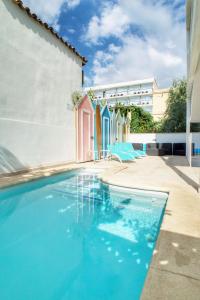 basen z niebieskimi krzesłami obok budynku w obiekcie Apartments Beach 4U - Can Pastilla w mieście Can Pastilla