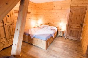 una camera con un letto in una baita di tronchi di Chalet LEPERVIERE a Vaujany