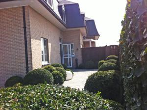 Uma casa com um monte de arbustos à frente. em Villa Valentino em Hasselt