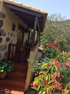 una casa con porche y algunas flores en Casa Rural Las Rosas, en Agulo