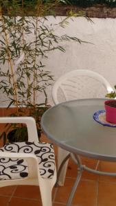 a table and two white chairs and a table and a plant at Casa Andaluza in La Zubia