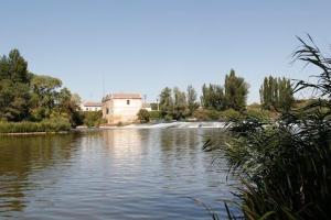 a river with a building in the middle of it at Casa Ana in Villamarciel
