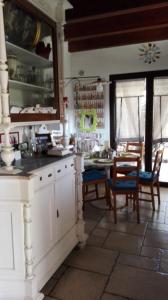 cocina con armarios blancos, mesa y sillas en Le Sete, en Bari