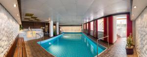 ein großer Pool in einem Gebäude in der Unterkunft Hotel Alpenhof in Bad Wörishofen