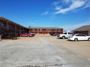 a parking lot with cars parked in front of a building at Heritage Inn in Duncan