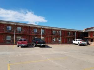 a building with two trucks parked in a parking lot at Heritage Inn in Duncan