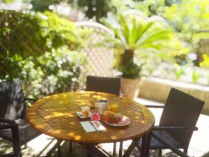 a wooden table with a plate of food on it at Hotel Alexandre III in Cannes