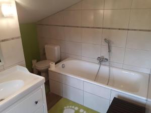 een badkamer met een bad, een toilet en een wastafel bij Escale de Brionsart in Gesves