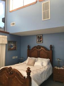 a bedroom with a large bed with blue walls at Chisolm Trails End B&B in Prescott