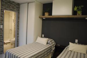 a bedroom with a bed and a bathroom with a toilet at Darwin Apart Hotel in Salta