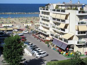 リミニにあるSplendido appartamento sul mareの駐車場とビーチ付きのアパートメントビル