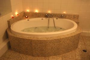 een badkamer met een bad met kaarsen bij Allotino Pension in Nafplio