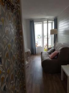 ein Wohnzimmer mit einem Sofa und einem Fenster in der Unterkunft Côte de Granit Rose in Perros-Guirec